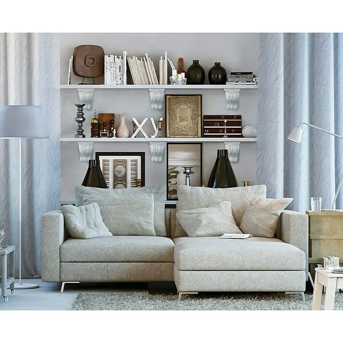 Dekoelement Melina - 19,5 x 20 cm, Expandiertes Polystyrol (EPS), Weiß - Das graue Ecksofa lädt mit seinen vielen Kissen zum Entspannen ein. Das Sofa steht vor einem Regal, das mit Dekoartikeln bestückt ist.