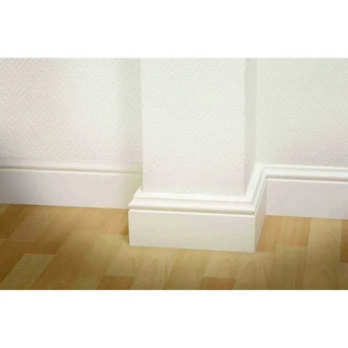 Fußleiste CF 12 - 200 x 1,5 x 12 cm, Weiß, HD Polymer - Nahaufnahme von weißen Sockelleisten und einer Wand, die einen sauberen Übergang zum Boden bildet. Die Sockelleisten bieten einen stilvollen Akzent.