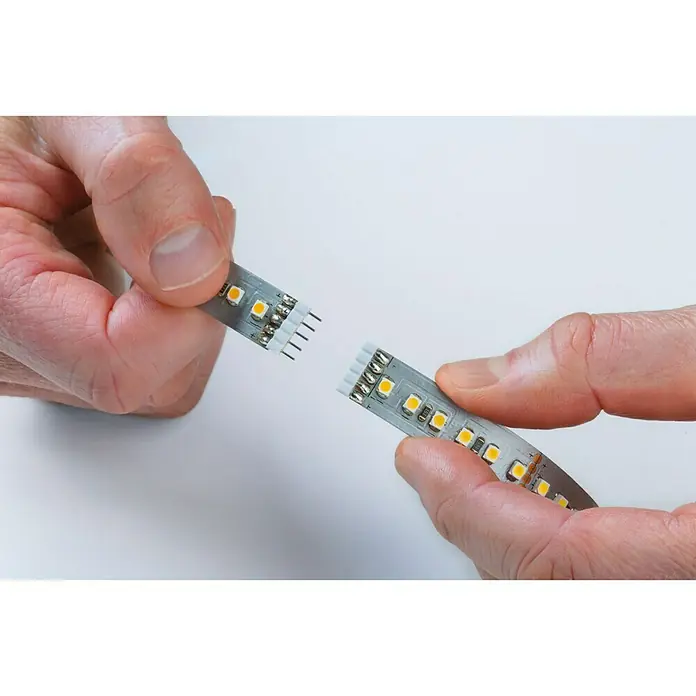 Paulmann MaxLED 500 LED-Band unbeschichtet - Länge: 1 m, Lichtfarbe: Tageslichtweiß, 6 W, 550 lm, Unbeschichtet - Zwei Hände halten ein LED-Band mit gelben LEDs und einem weißen Stecker zum Verbinden mit einem anderen LED-Band.