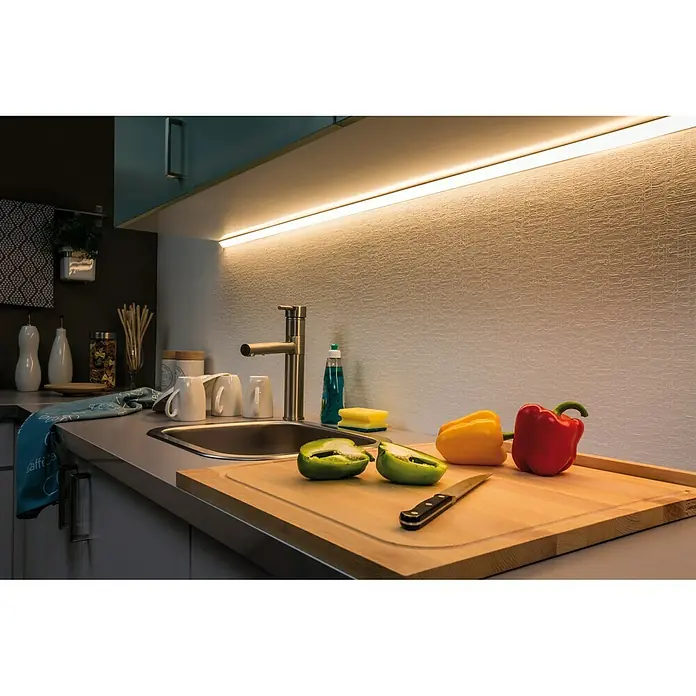 Paulmann MaxLED 500 LED-Band Basisset beschichtet - Länge: 3 m, Lichtfarbe: Warmweiß, 20 W, 1.650 lm, 24 V - 36 V - Küchenspüle mit LED-Beleuchtung über der Arbeitsplatte und Schneidebrett mit Paprika.