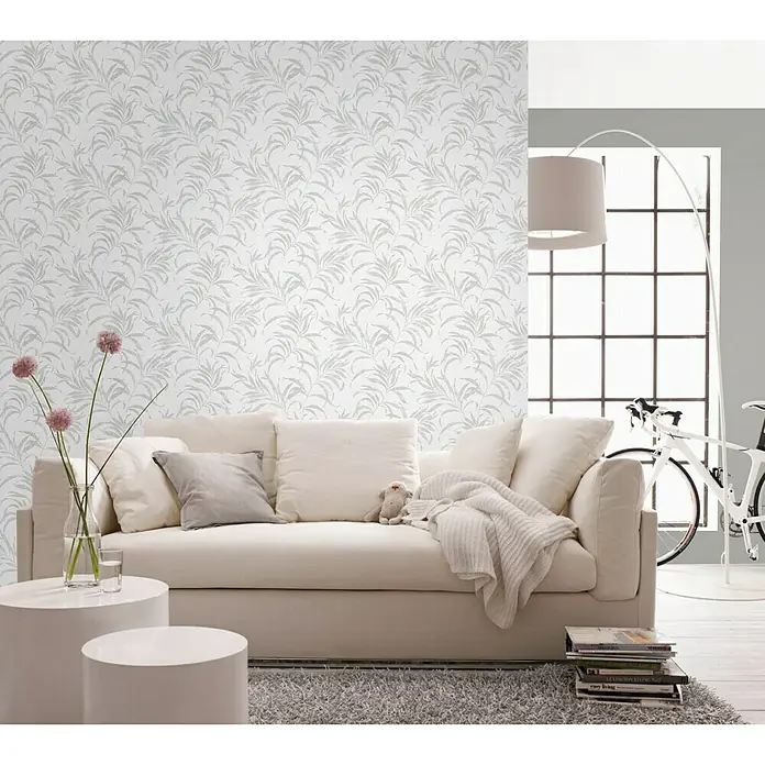 Papel pintado Hojas - Plateado, 10 x 0,53 m - Un salón elegante con un sofá blanco, una mesa de centro y un papel pintado decorativo.
