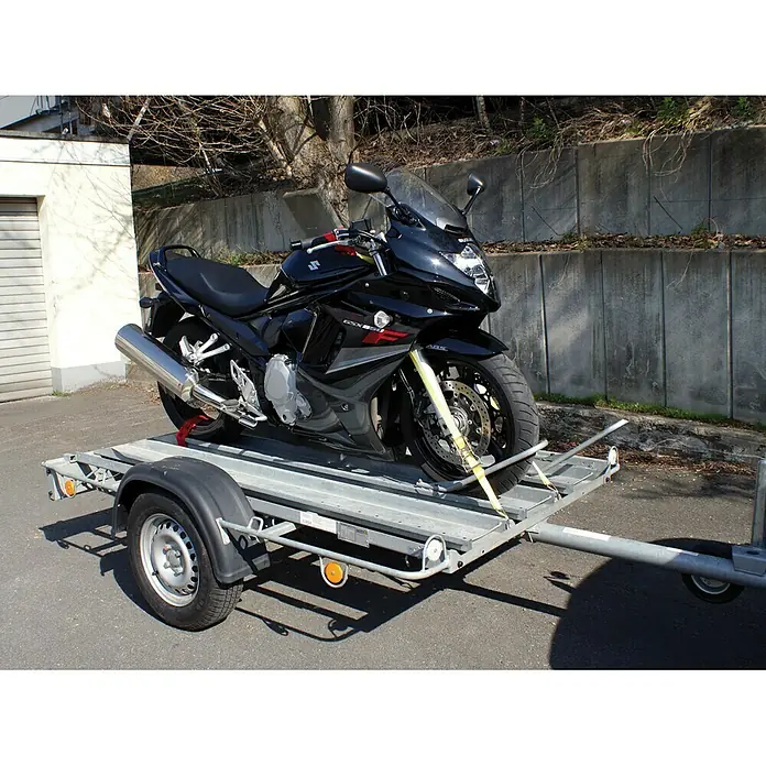 LAS Spanngurtsystem - Geeignet für: Motorräder, 6 -tlg. - Schwarzes Suzuki-Motorrad, gesichert auf einem grauen Anhänger für den sicheren Transport.