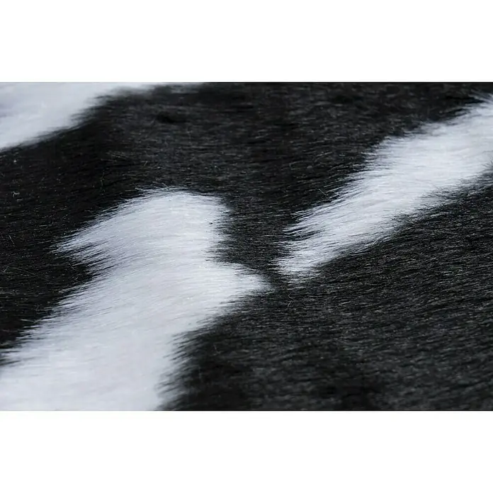Kunstfell Rodeo - Schwarz/Weiß, 200 x 150 cm, 100 % Polyester, Kuh - Nahaufnahme eines stilvollen Kuhfellteppichs mit schwarz-weißem Muster, der jedem Raum einen Hauch von Wildnis verleiht.