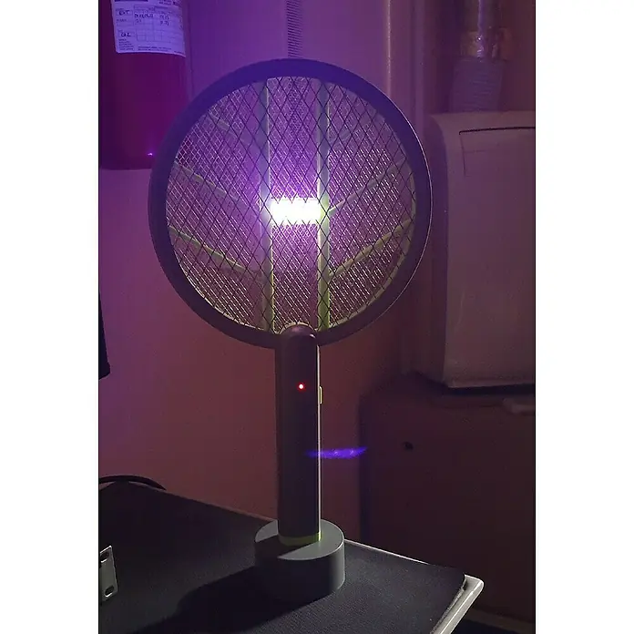 Matainsectos eléctrico Raqueta + Zapper - A batería, Gris/Verde - Primer plano de un matamoscas eléctrico con luz UV, situado sobre una superficie, diseñado para atraer y eliminar insectos.
