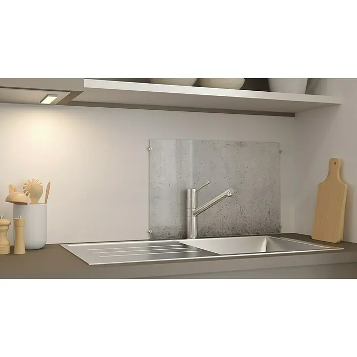 CUCINE Küchenrückwand - Cracked Concrete, 60 x 40 cm, Stärke: 6 mm, Einscheibensicherheitsglas (ESG) - Nahaufnahme einer modernen Küchenspüle aus Edelstahl mit Armatur und Spritzschutz vor einer hellen Wand.