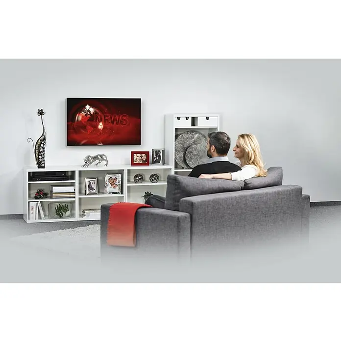 Hama TV-Wandhalterung starr - Passend für: Bildschirmdiagonale 32 - 75″, 81 - 191 cm, Belastbarkeit: 40 kg, Wandabstand: 2,5 cm - Wohnzimmer mit TV-Gerät und einem weißen Lowboard mit Regalen.