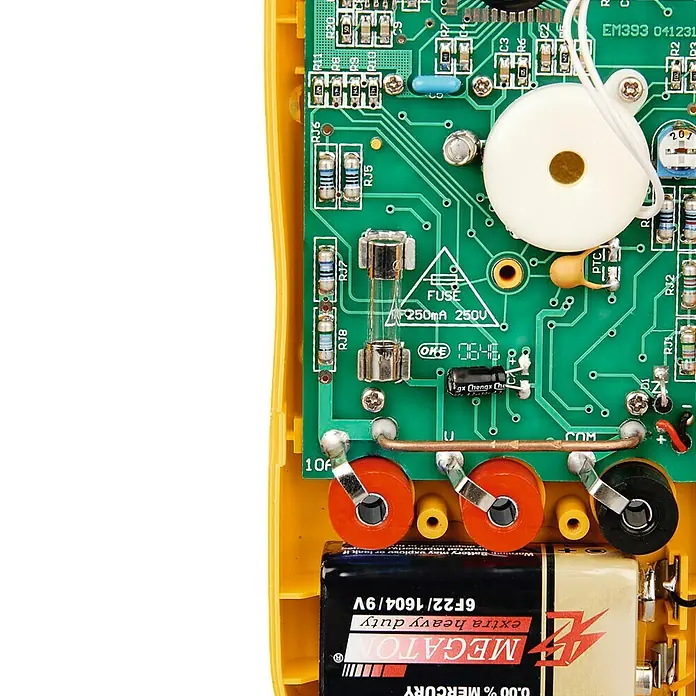 Hama Digital-Multimeter - Messkategorie: CAT III 300 V - Nahaufnahme eines Multimeters, das eine Batterie, eine Sicherung und elektronische Bauteile auf einer gelben Platine zeigt.