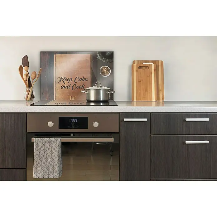 CUCINE Küchenrückwand - Keep Calm and Cook, 60 x 40 cm, Stärke: 6 mm, Einscheibensicherheitsglas (ESG) - Küchenzeile mit Arbeitsplatte, Herd und Küchenutensilien wie Schneidebrettern und Kochlöffeln. Ein Topf steht auf dem Herd.