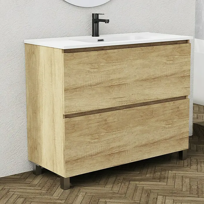 Artysan Conjunto de mueble de baño Ariel - Ancho: 100 cm, Nature, 3 pzs. - Un tocador de baño con dos cajones y una encimera blanca colocado en un suelo de madera. Los cajones tienen un acabado de madera clara.