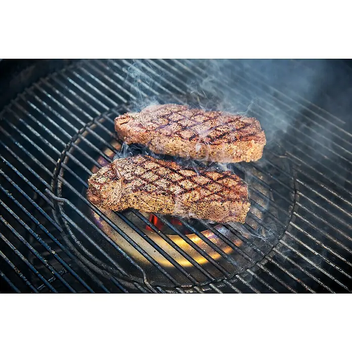 Weber Grilleinsatz Temperaturregler - Ø x H: 46,5 x 11,5 cm, Edelstahl, Passend für: Holzkohle Kugelgrills mit 57 cm Durchmesser - Zwei saftige Steaks brutzeln auf einem Grill, perfekt gegrillt mit verlockenden Grillstreifen und köstlichem Rauch, bereit für den Genuss.