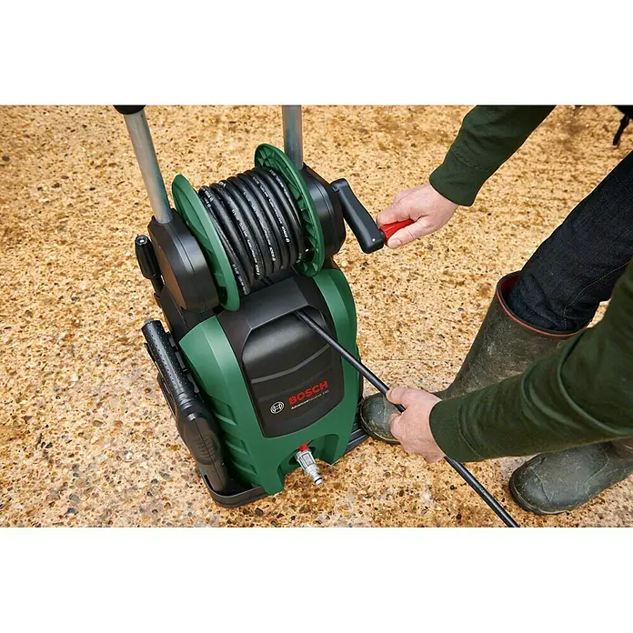 Bosch Hochdruckreiniger AdvancedAquatak 140 - 2.100 W, Betriebsdruck: 140 bar - Ein Bosch Hochdruckreiniger mit Schlauchtrommel wird von einer Person bedient, die den Schlauch hält und die Kurbel dreht.