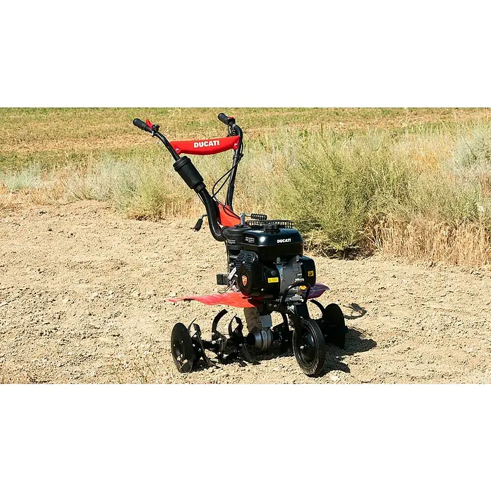 Ducati Azada de gasolina DTL7000 - 4,3 kW, 4 tiempos, Recomendación máxima de superficie: 1.500 m² - El motocultor Ducati, una máquina robusta para la preparación del suelo. El motocultor es rojo, con robustas fresas negras.