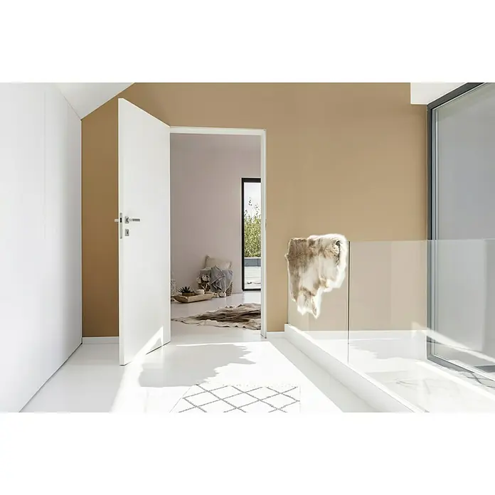 SCHÖNER WOHNEN-Farbe Wandfarbe Trendfarbe - Macchiato, Matt, 1 l, Konservierungsmittelfrei - Das Bild zeigt eine offene weiße Tür und einen hellen Raum mit einem eleganten Design und einem Fellteppich. Moderne Inneneinrichtung mit Fokus auf Details.