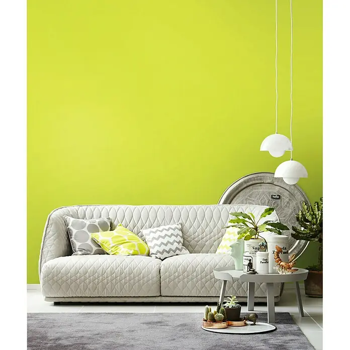 SCHÖNER WOHNEN-Farbe Wandfarbe Trendfarbe - Fresh, Matt, 2,5 l, Konservierungsmittelfrei - Helles Wohnzimmer mit einem modernen, gesteppten Sofa, grüner Wand und dekorativen Elementen.