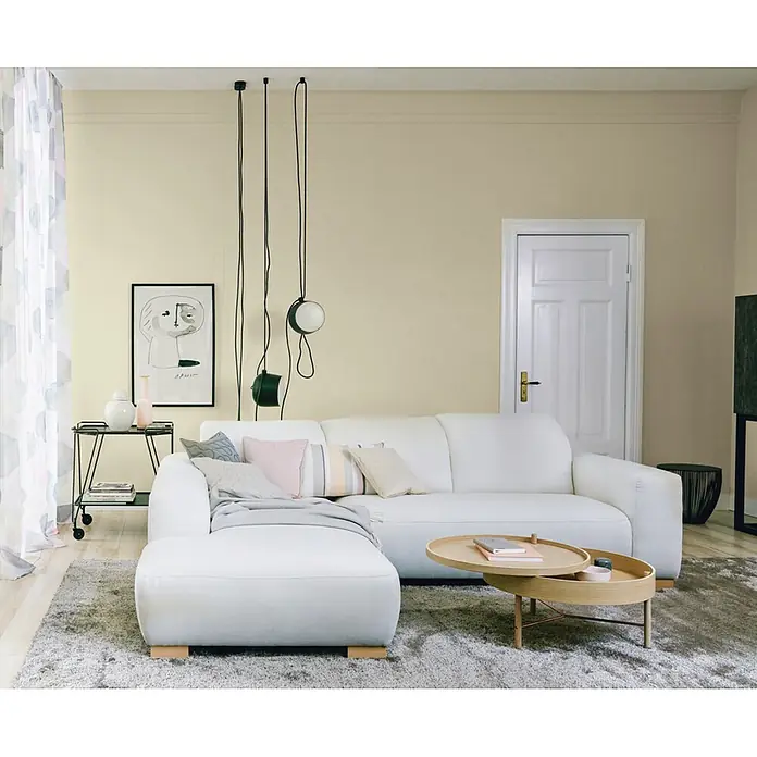 SCHÖNER WOHNEN-Farbe Wandfarbe Trendfarbe - Moon, Matt, 2,5 l - Blick auf ein stilvolles Wohnzimmer mit einem modernen weißen Sofa, das zum Entspannen einlädt. Die sanften Farben und das minimalistische Design schaffen eine ruhige Atmosphäre.