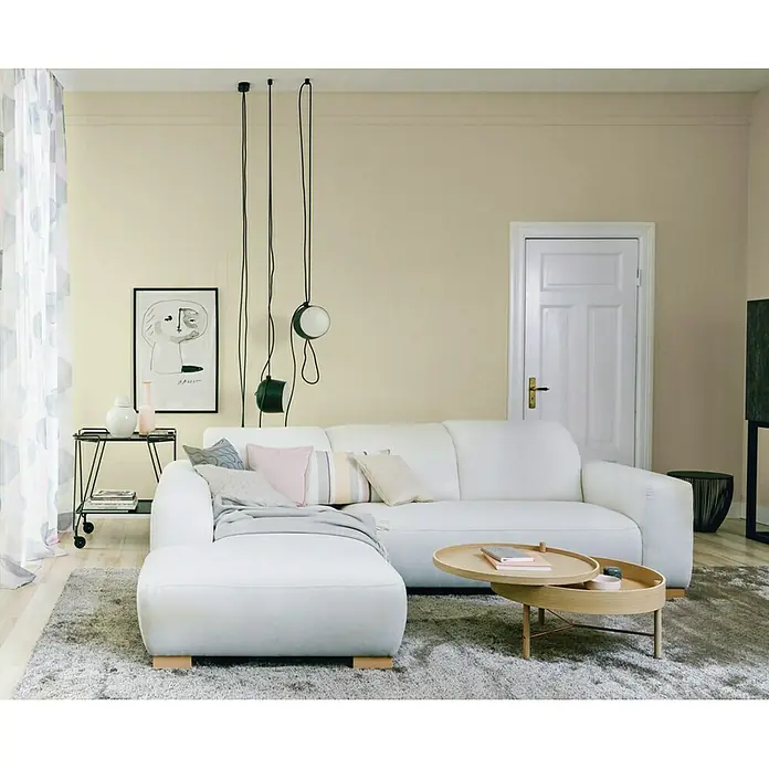 SCHÖNER WOHNEN-Farbe Wandfarbe Trendfarbe - Moon, Matt, 1 l, Konservierungsmittelfrei - Blick auf ein stilvolles Wohnzimmer mit einem modernen weißen Sofa, das zum Entspannen einlädt. Die sanften Farben und das minimalistische Design schaffen eine ruhige Atmosphäre.