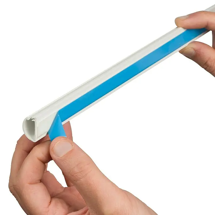 D-Line Kabelkanal Halbrund - 1 m, 20 x 10 mm, Weiß - Eine Person entfernt die blaue Schutzfolie von einer selbstklebenden Kabelkanal-Abdeckung. Ideal für die Kabelführung.