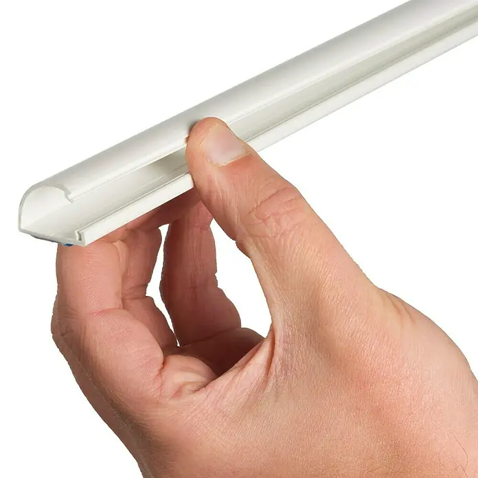 D-Line Kabelkanal Halbrund - 1 m, 20 x 10 mm, Weiß - Eine Hand hält ein weißes Kabelkanal-Profil, das für die Verlegung von Kabeln im Innenbereich verwendet wird. Ideal zur unauffälligen Kabelorganisation.