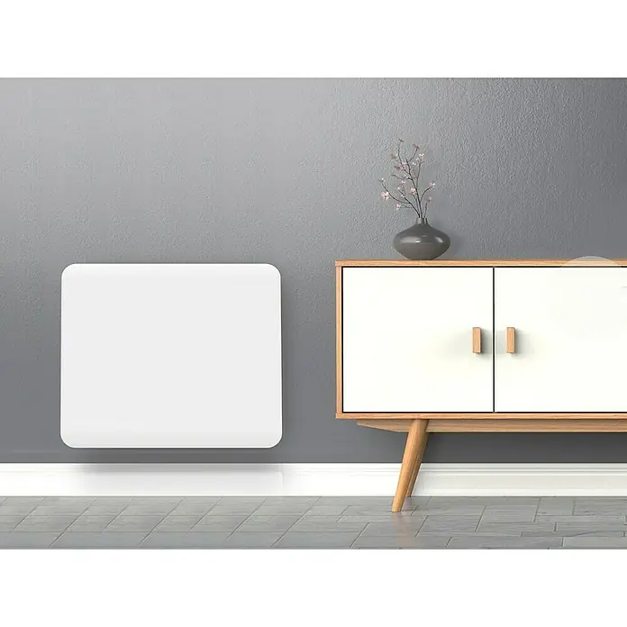 Purline Emisor térmico Ceramic A1000 WiFi - 1.000 W, Blanco, 9 x 60 x 50 cm, Cerámico - Primer plano de un radiador blanco sobre una pared gris, junto a un armario de madera con un jarrón encima.