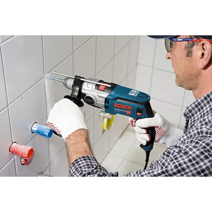 Bosch Professional Schlagbohrmaschine GSB 20-2 - 850 W, Schnellspannbohrfutter, Ohne Steinbohrer-Set - Ein Handwerker bohrt mit einer Bosch Professional Schlagbohrmaschine ein Loch in eine geflieste Wand.