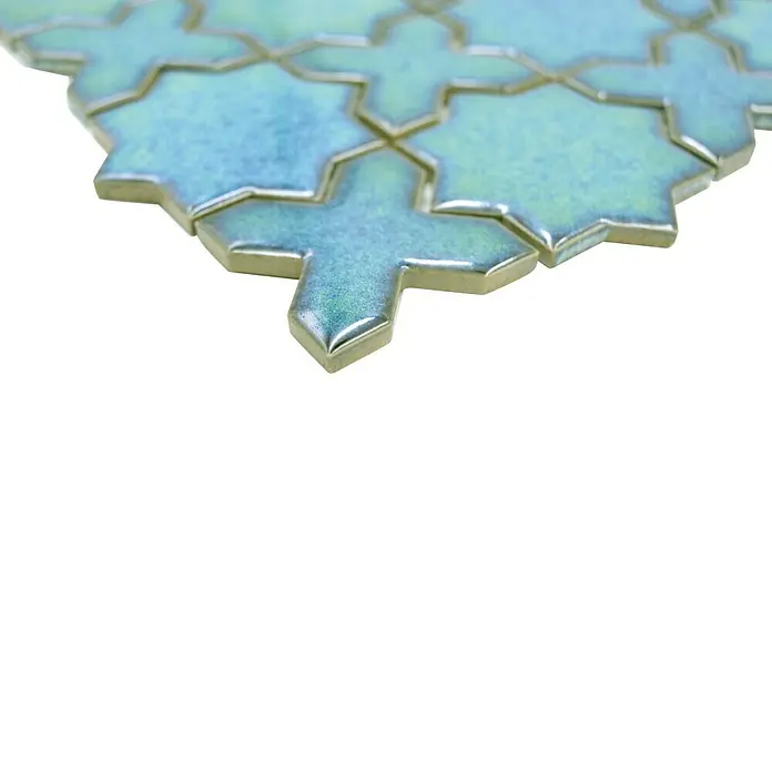 Mosaikfliese Starmix CG SXS 10 - 29,6 x 29,6 cm, Grün, Glänzend - Nahaufnahme von schimmernden, blauen Keramikfliesen in Form von Kreuzen und Sternen, die ein dekoratives Muster bilden.
