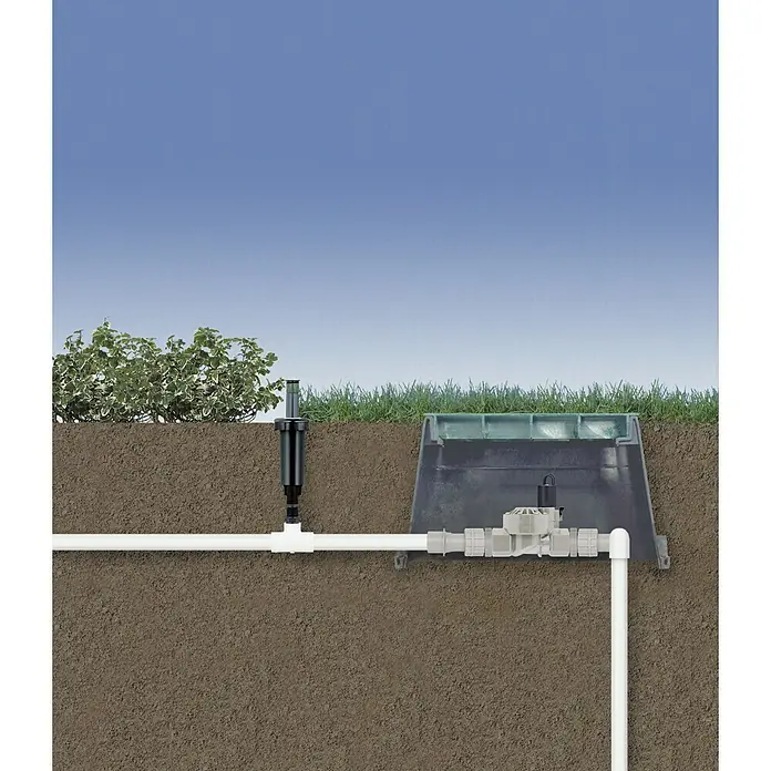 Electroválvula rosca - ¾″, Negro - Ilustración de un sistema de riego subterráneo, con un cabezal de aspersión y caja de válvulas en el jardín.