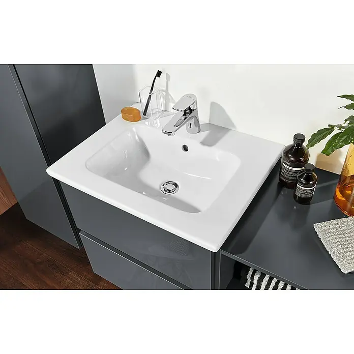 Sanipa Badmöbel-Set Solo One Euphoria - 78 cm, Anthrazit - Ein Waschbecken mit Armatur, Seife, Zahnbürste und Aesop-Produkten. Das Becken ist weiß und modern.