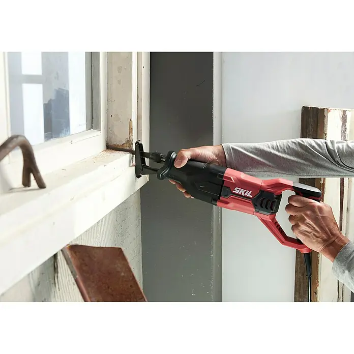 Skil Säbelsäge 4961 AA - 900 W, Hublänge: 29 mm - Eine SKIL-Reciprosäge wird zum Schneiden von Holz in einem Fensterrahmen verwendet, was die Vielseitigkeit des Werkzeugs hervorhebt.