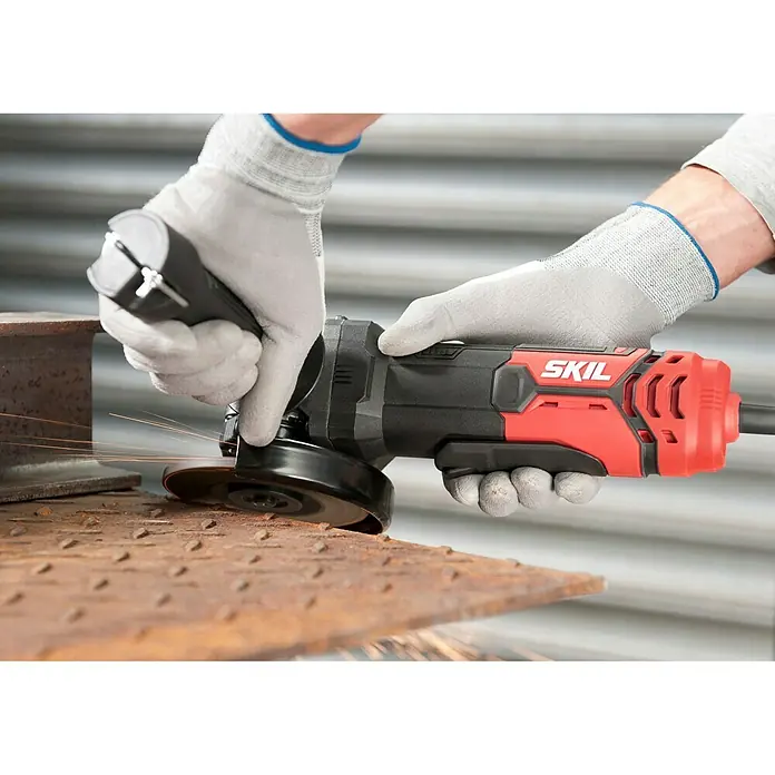 Skil Elektro-Winkelschleifer 9131 AA - 720 W, Durchmesser Scheibe: 125 mm, Leerlaufdrehzahl: 0 U/min - 12.000 U/min - Eine rote und schwarze SKIL-Flex mit Handschuhen in Aktion beim Schneiden von Metall, wodurch Funken entstehen.