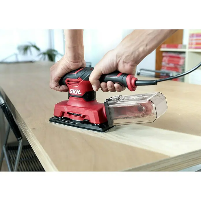Skil Elektro-Schwingschleifer 7362 AA - 280 W - Hier ist ein roter SKIL-Handschleifer in Aktion. Perfekt für feine Schleifarbeiten und präzise Ergebnisse bei Holzprojekten.