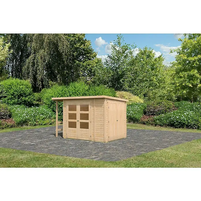 Karibu Gerätehaus Multi - Außenmaß inkl. Dachüberstand (B x T): 300 x 186,5 cm, Holz, Natur - Ein helles Holzgartenhaus mit Doppeltüren und einem Vordach steht auf einem gepflasterten Bereich inmitten eines üppigen Gartens.