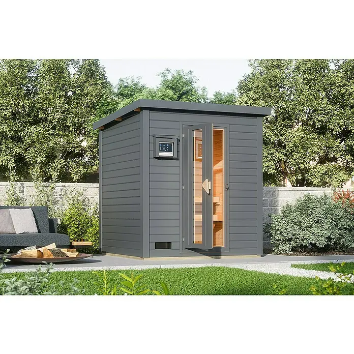 Karibu Saunahaus Hytti - 9 kW Saunaofen mit externer Steuerung, Terragrau, L x B x H: 196 x 196 x 228 cm - Dieses Bild zeigt eine moderne Außensauna mit Holztür und einem Bedienfeld an der Seite, umgeben von Grün.