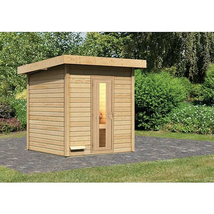 Karibu Saunahaus Hytti - Ohne Ofen, L x B x H: 196 x 196 x 228 cm, Natur - Außenaufnahme einer Holzsauna im Garten, die durch ihre helle Farbe und ihr schlichtes Design auffällt. Die Sauna bietet Entspannung im eigenen Garten.