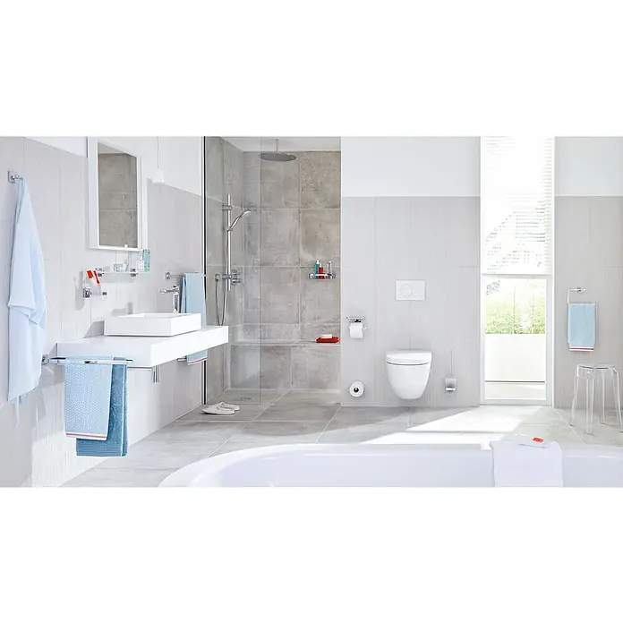 Tesa Deluxxe Handtuchring - Chrom, Glänzend - Ein modernes Badezimmer mit weißen Sanitärobjekten, grauen Fliesen und minimalistischem Design, das eine entspannende Atmosphäre schafft.