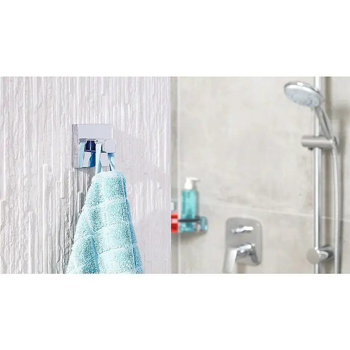 Tesa Deluxxe Handtuchhaken - Chrom, Glänzend - Ein blaues Handtuch hängt an einem modernen, quadratischen Chrom-Handtuchhaken an einer weißen Wand im Badezimmer.