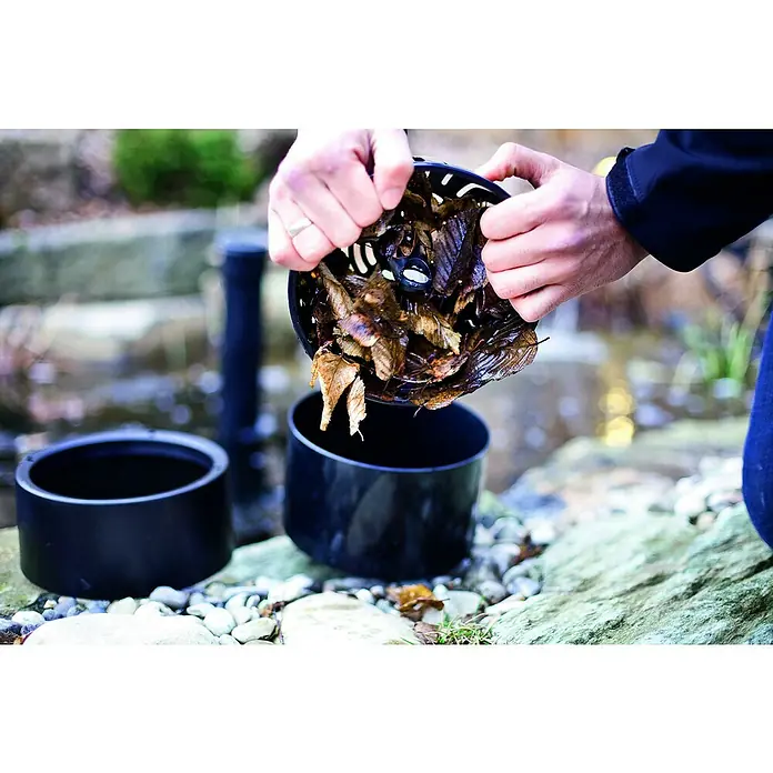 Heissner Skimmer - Fördermenge pro Std.: 2.500 l - Reinigen eines Teichfilters mit Blättern in einem Garten, die in einen schwarzen Filterbehälter geleert werden.\n