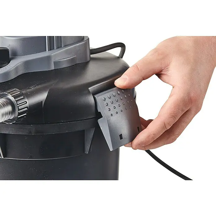 Heissner Druckfilter-Set - 25 W, Fördermenge pro Std.: 1.500 l - Detailaufnahme eines Teichfilters mit einer Hand, die eine graue Abdeckung hält. Fokus auf der Filterkomponente.