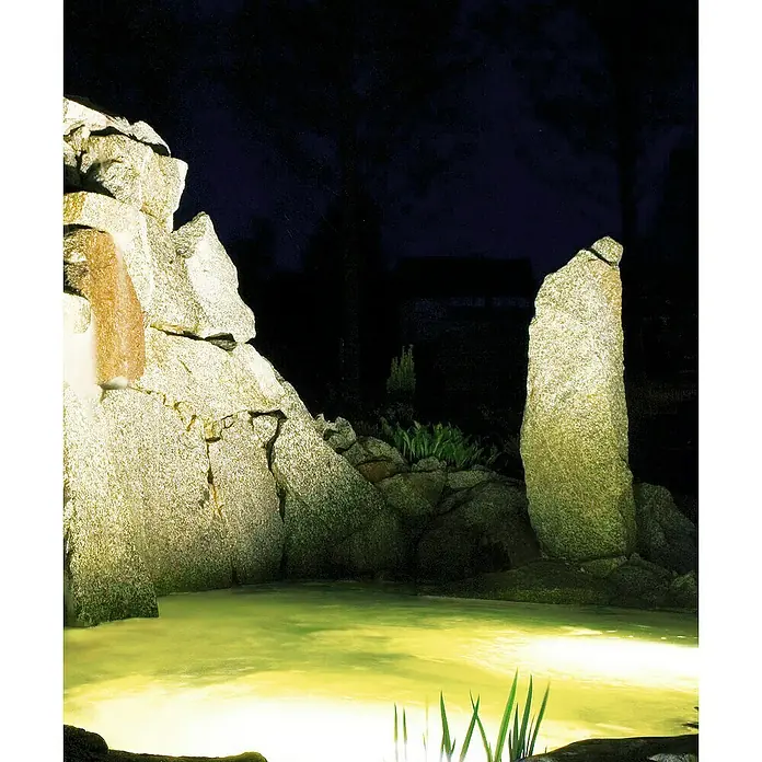 Heissner Teichbeleuchtung - 4,5 W, Warmweiß - Nachtaufnahme eines beleuchteten Teichs mit Wasserfall und Felsen, die eine friedliche Atmosphäre schaffen.