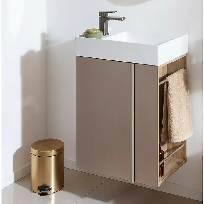 Camargue Marea Badmöbel-Set Mini - Gesamtbreite Badmöbel: 50 cm, Berg Eiche/Goldbronze, Matt - Modernes Badezimmer mit Waschbeckenunterschrank in Beige, das Stauraum und Handtuchhalter bietet, und einem goldenen Treteimer.