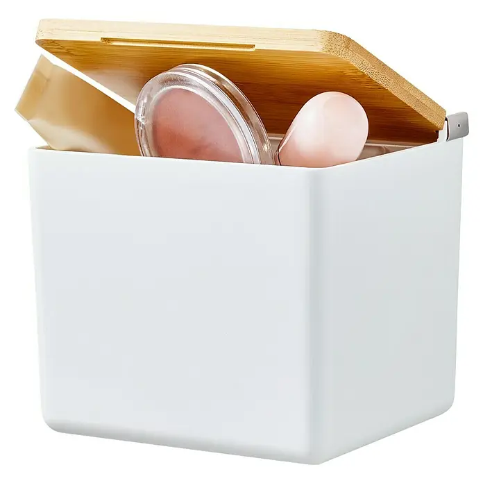 Tesa Aufbewahrungsbox Baboo - L x B x H: 12,2 x 10,2 x 11 cm, ABS-Kunststoff, Weiß/Bambus - Ein weißer Behälter mit Bambusdeckel ist leicht geöffnet und zeigt Kosmetikprodukte im Inneren. Ideal für Bad und Ordnungsliebe.