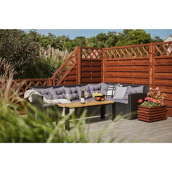 Pflanzkasten Torino - Außenmaß (L x B x H): 59 x 34 x 34 cm, Holz, Teak - Einladende Gartenlounge mit grauen Kissen, Holztisch, Wein und Blumenkasten vor einem dekorativen Holzzaun für entspannte Stunden im Freien.