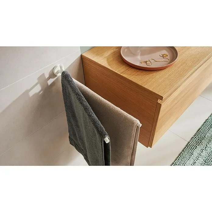 Tesa Moon Handtuchhalter - 2-armig, Weiß, Matt - Handtücher hängen an einem weißen Handtuchhalter im Badezimmer neben einem Waschtisch mit einer Schale und einer Halskette.