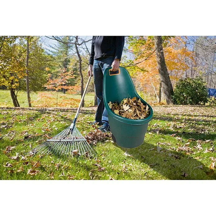 Keter Trolley de jardín Easy Go - Verde oscuro, Capacidad volumétrica: 55 l - Escena de jardín con rastrillo de hojas y recogedor portátil lleno de hojas de otoño, para jardinería eficiente.