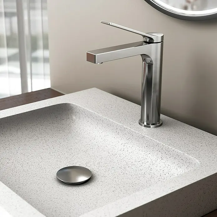 IO Tarsio Grifo de lavabo - Cromo - Primer plano de un grifo de baño moderno con un diseño elegante, complementado por un lavabo gris.