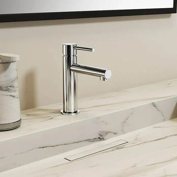 IO Grifo de lavabo Mio - Cromo, Brillante - Primer plano de un moderno grifo de baño cromado con un lavabo de mármol y un dispensador de jabón, que muestra un diseño de baño elegante.
