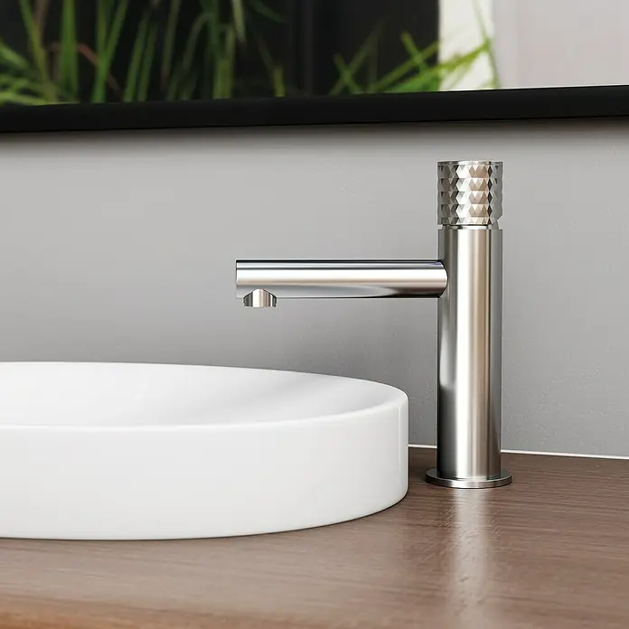 IO Grifo de lavabo Radio - Cromo, Brillante - Primer plano de un moderno grifo de baño cromado con un distintivo mango facetado y una forma de lavabo redonda y sencilla.