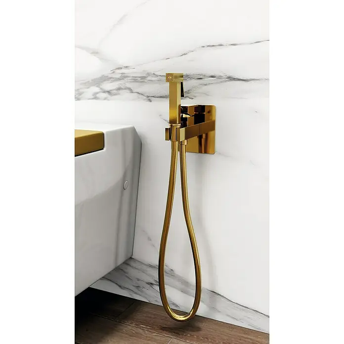 IO Orion Ducha higiénica inodoro - Oro - Grifo de bidé dorado con ducha de mano sobre pared de mármol. Diseño elegante para baños modernos, un detalle lujoso.