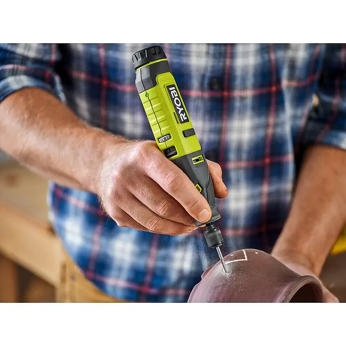 Ryobi Graviermesser RAR101 - Arbeitsdurchmesser: 1,6 mm, Passend für: Rotationswerkzeuge mit 3,2 mm (1/8") Spannzangenkapazität - Nahaufnahme eines Mannes, der mit einem Ryobi-Rotationswerkzeug ein Loch in einen Topf bohrt.