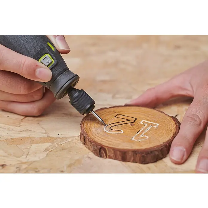 Ryobi Graviermesser RAR101 - Arbeitsdurchmesser: 1,6 mm, Passend für: Rotationswerkzeuge mit 3,2 mm (1/8") Spannzangenkapazität - Nahaufnahme von jemandem, der mit einem Rotationswerkzeug die Nummer 12 in eine Holzscheibe graviert.