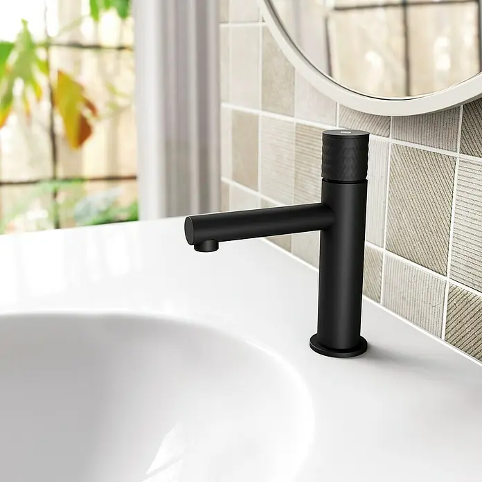 IO Grifo de lavabo Radio - Negro, Mate - Elegante grifo negro en un baño moderno con azulejos decorativos.